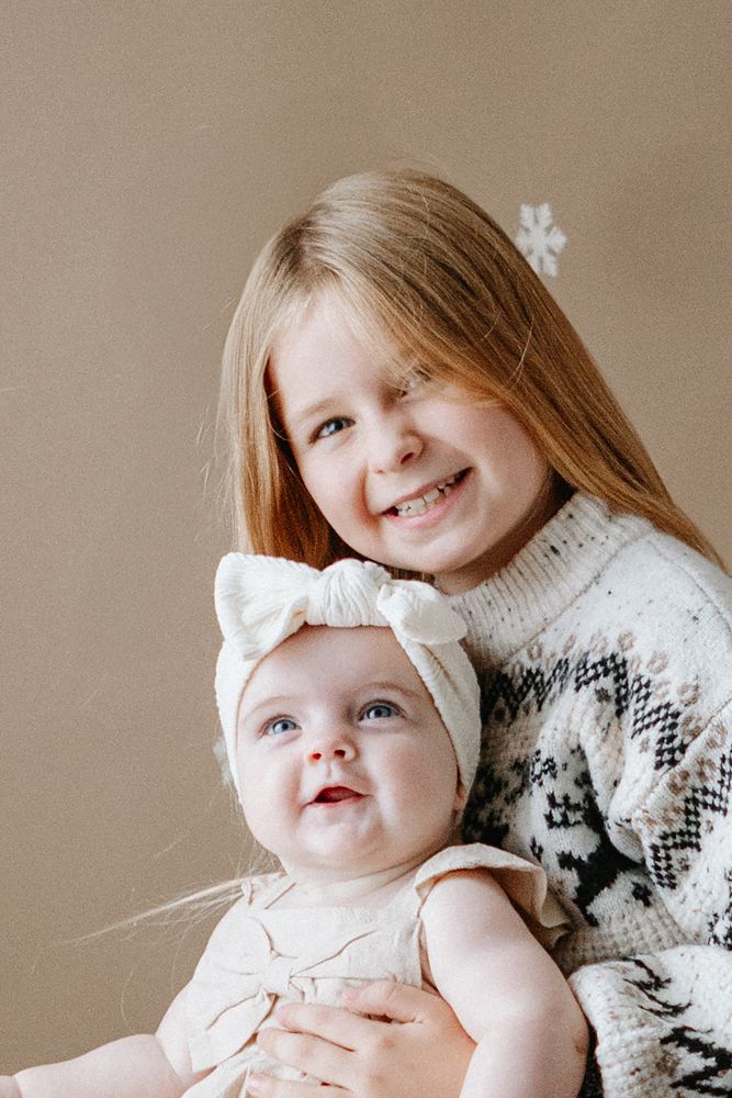 Portrait series showing joyful expressions and loving interactions between parent and baby in soft sepia tones.