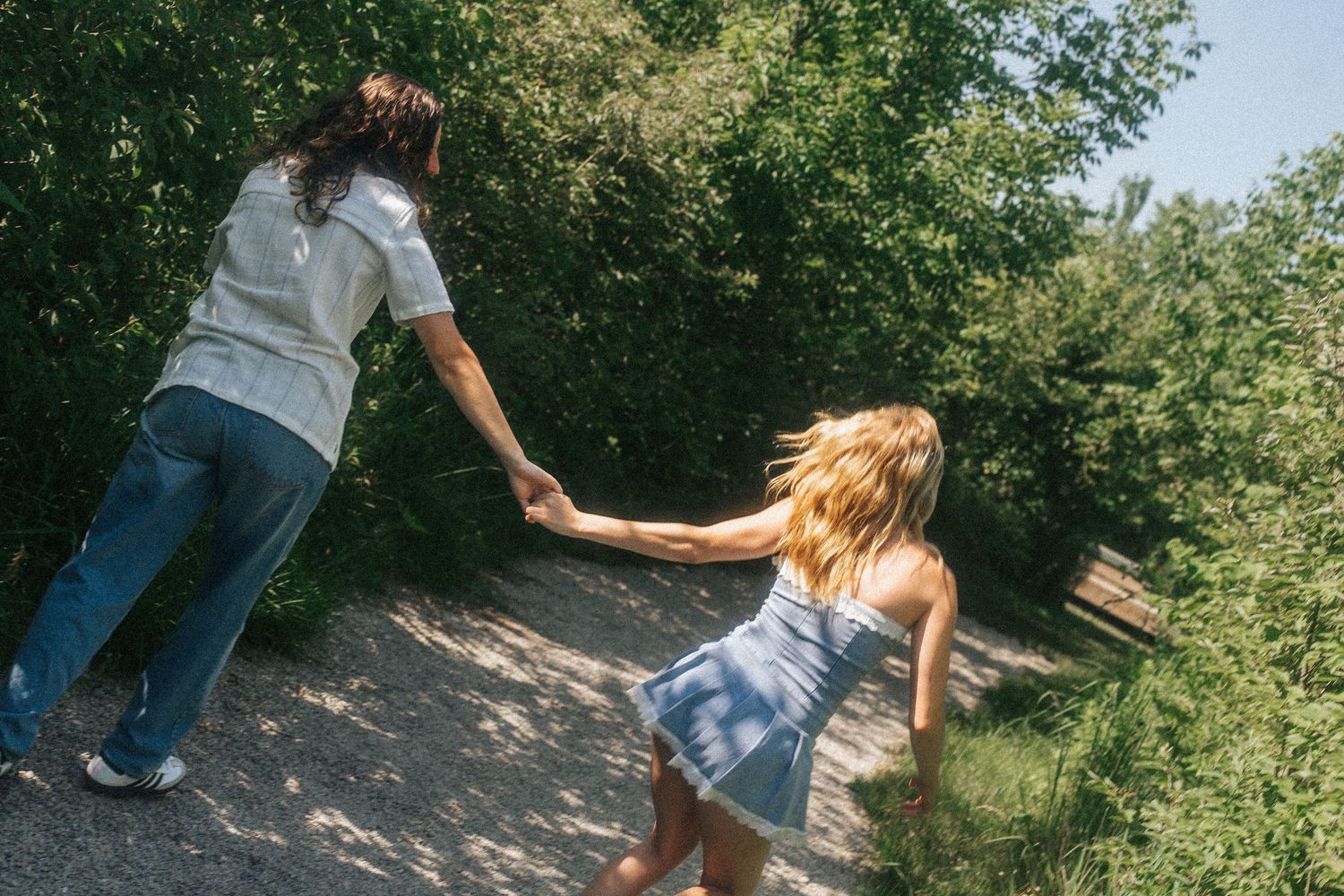 Playful sequence of people running through a wooded path during golden hour.