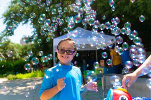 Group enjoying a sunny summer day playing with soap bubbles in the park.