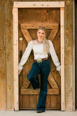 A series of three artistic photographs showing someone in jeans and white top posing by rustic wooden barn doors.
