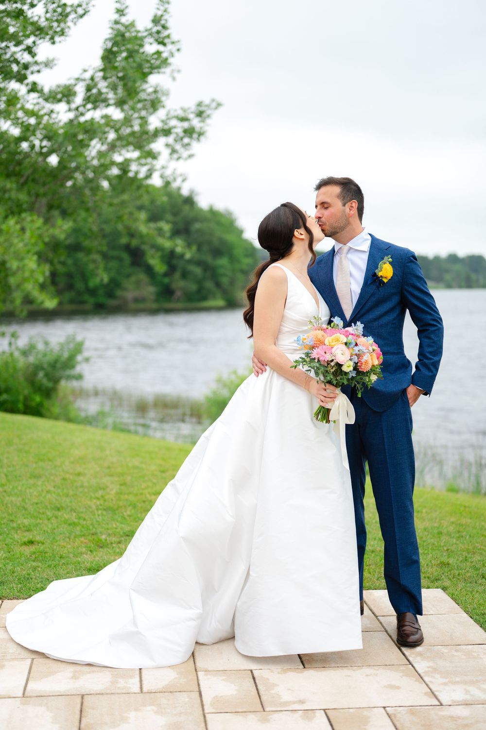 A bride and groom kiss and pose for a bridal portrait on their wedding day at the Lakehouse of Saphire Event Group in Halifax, MA