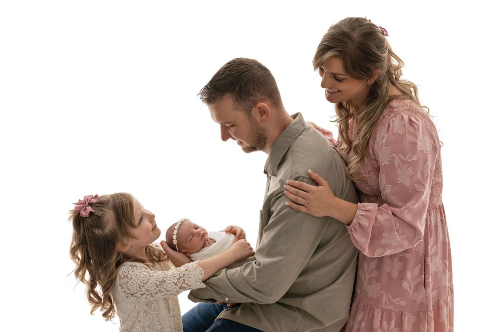 A family wearing coordinated pink and beige outfits poses together for a series of candid lifestyle photos.