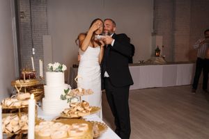 A couple shares their first dance at their wedding reception in an elegant white industrial-style venue.