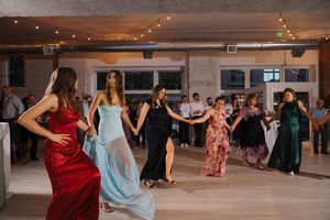 Dance students practice their moves in a mirrored studio during a ballroom dance class session.