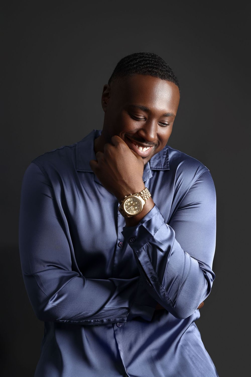 Expressive portrait series in blue shirt against dark background showing joyful emotions.