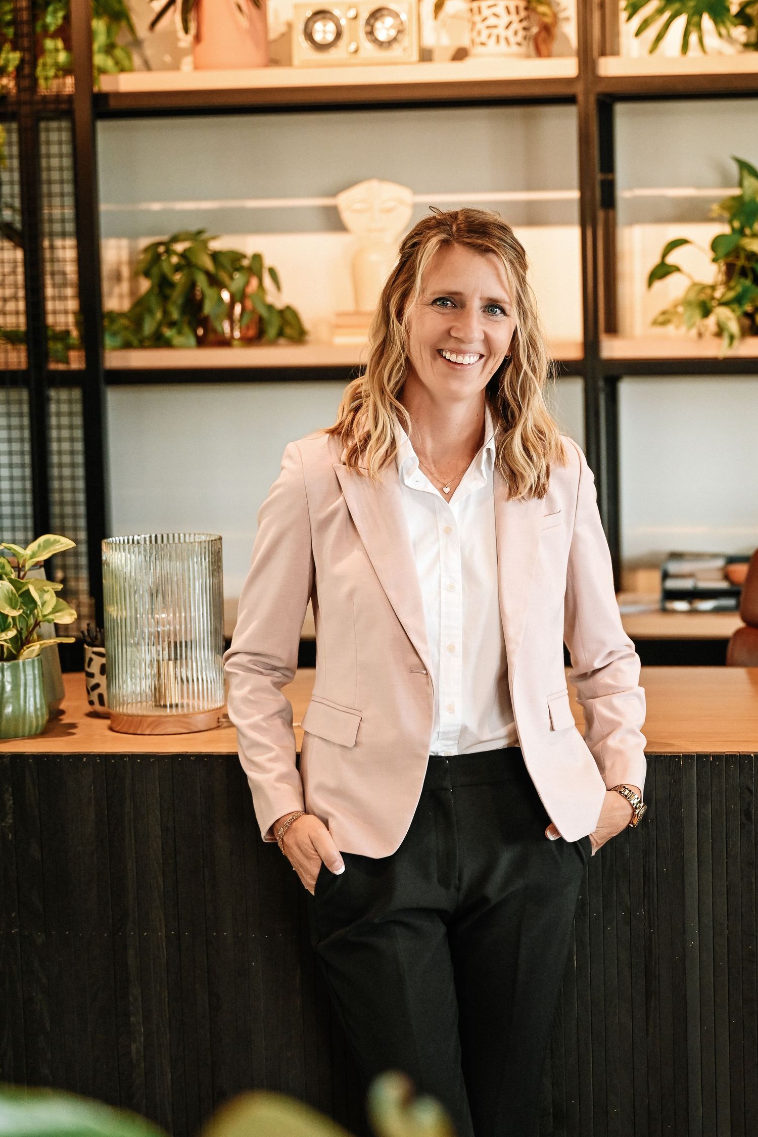 Professional headshots showing a woman in a pink blazer and white blouse against a modern office backdrop.