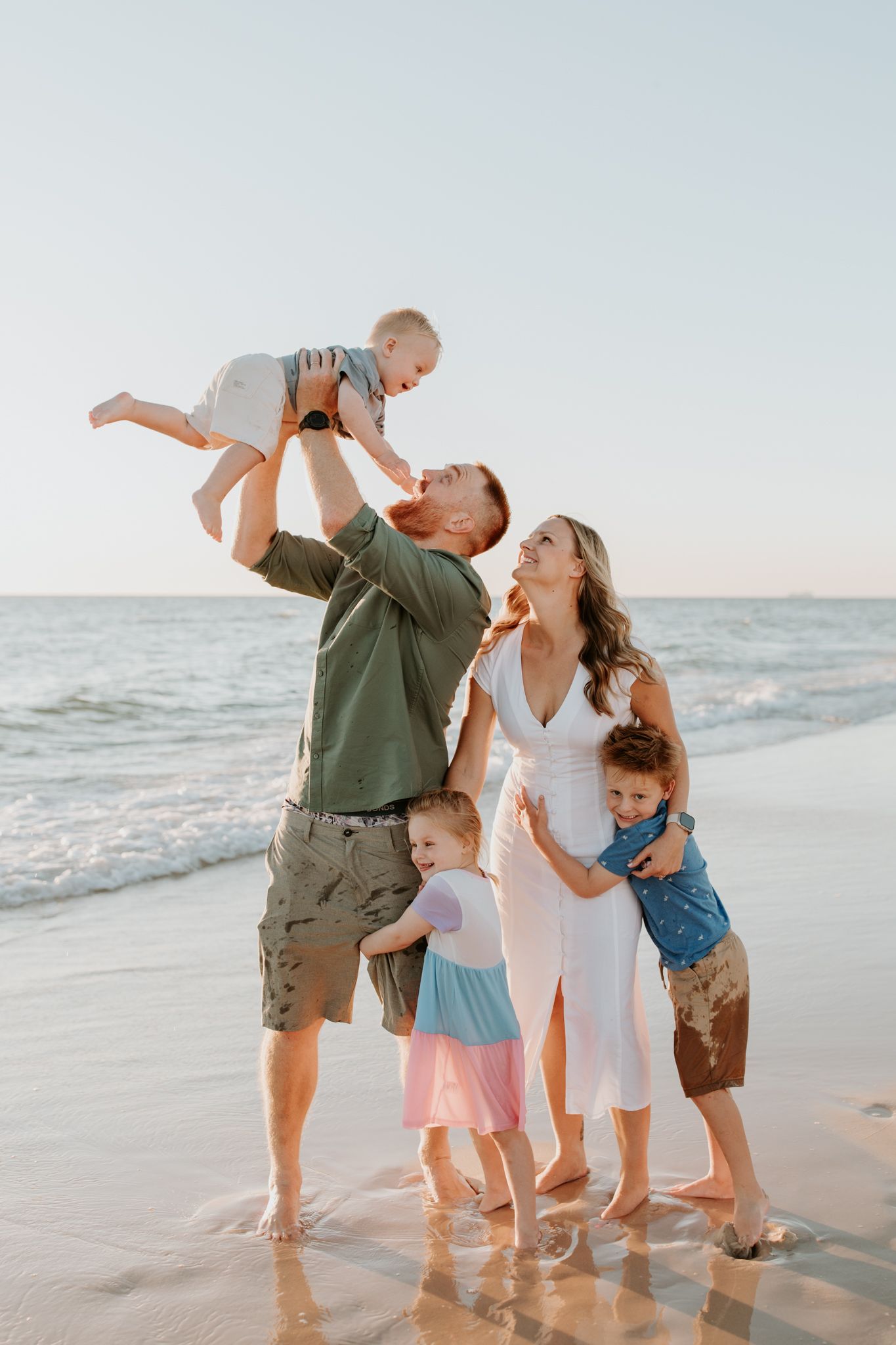 Lauren Lunn Photography captures an Adelaide family enjoying a golden sunset on the beach together as the waves hit the shoreline.