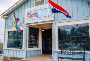 A light blue painted storefront with flags and banners hanging from the exterior.