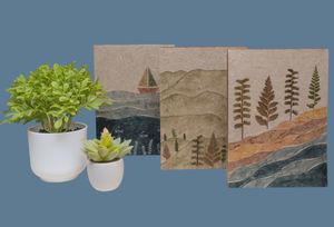 A photo of decorative handmade journals are displayed against a blue backdrop for a product photography session.