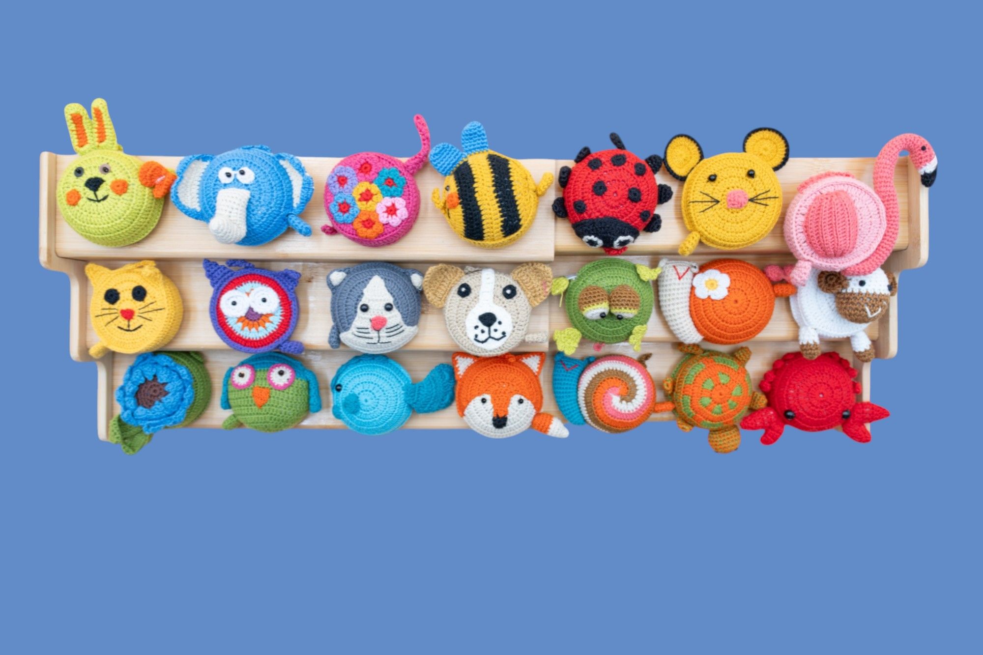 Adorable collection of colorful knitted animals including owls, ladybugs, bees, and other cute characters arranged in rows.