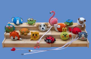 Colorful handmade knitted animals displayed on wooden steps for a product photography assignment.