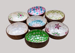 Colorful coconut shell bowls decorated with floral patterns and mosaic designs displayed in a row on a white surface.