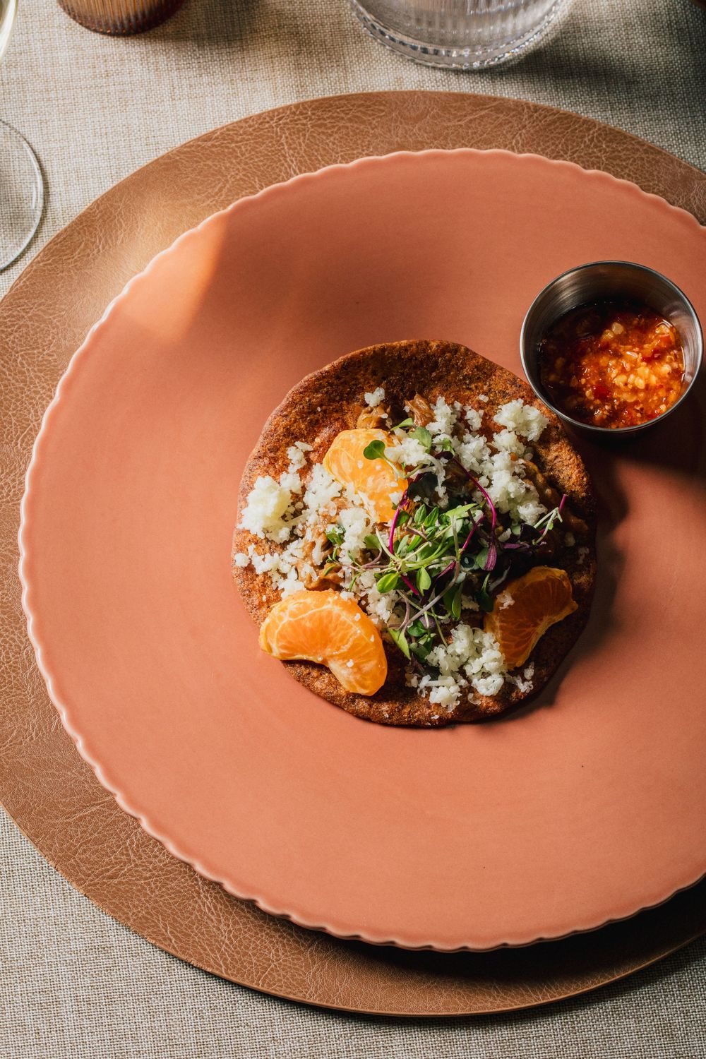 A series of plated dishes on terracotta plates showing the progression of a gourmet meal being assembled.