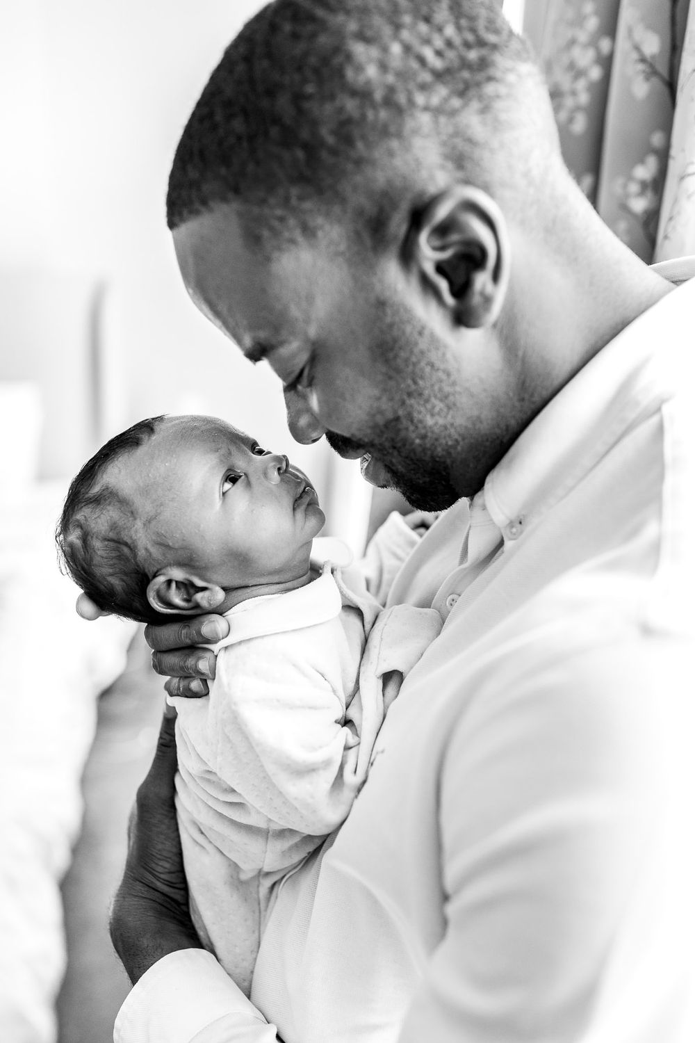 Dad holding his newborn baby boy close to his face