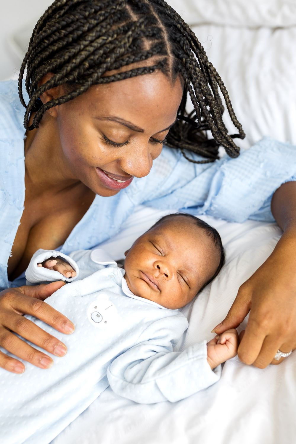 Honest and real newborn photo of London mum bonding with infant during in-home shoot