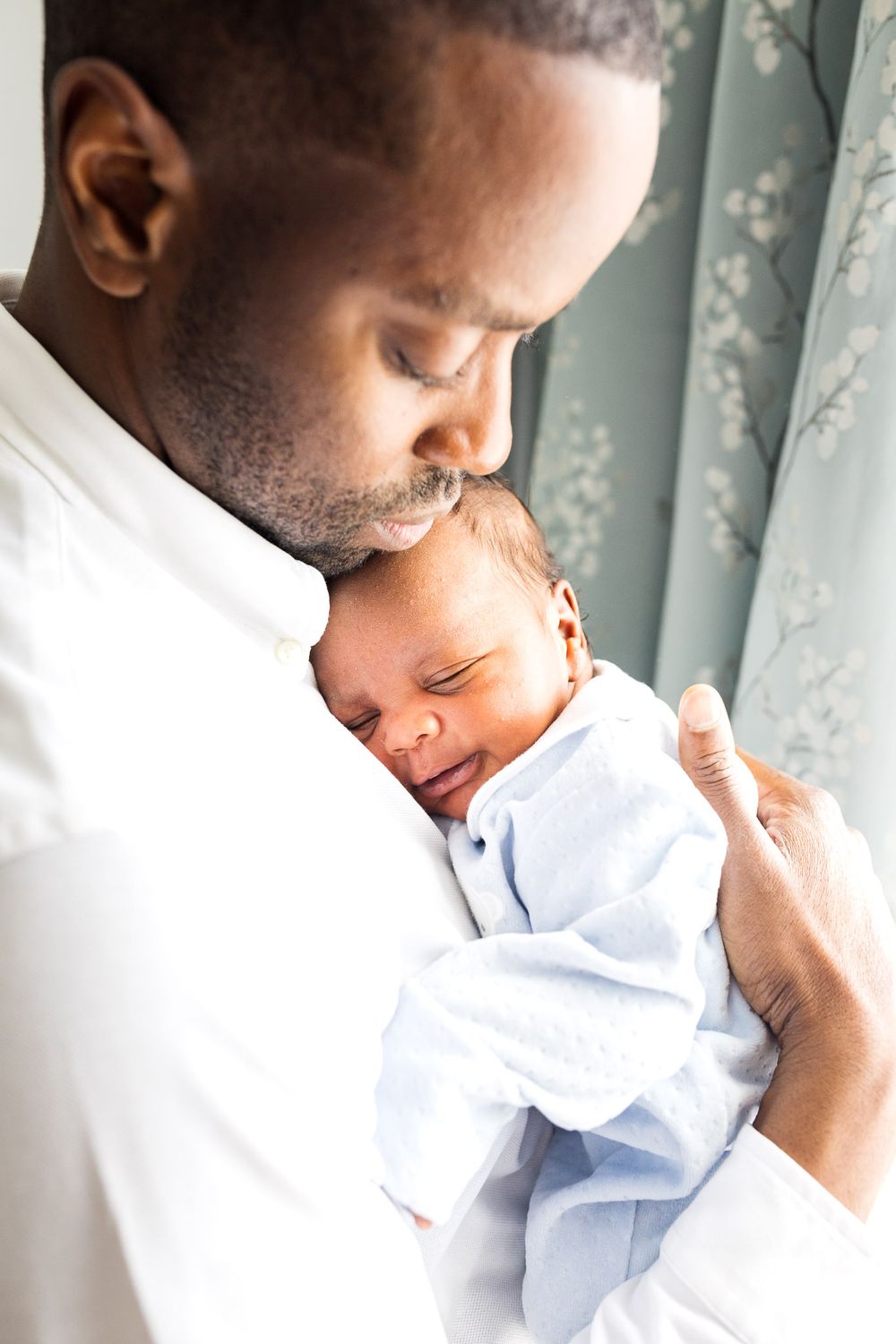 Dad holding his newborn baby boy on his chest