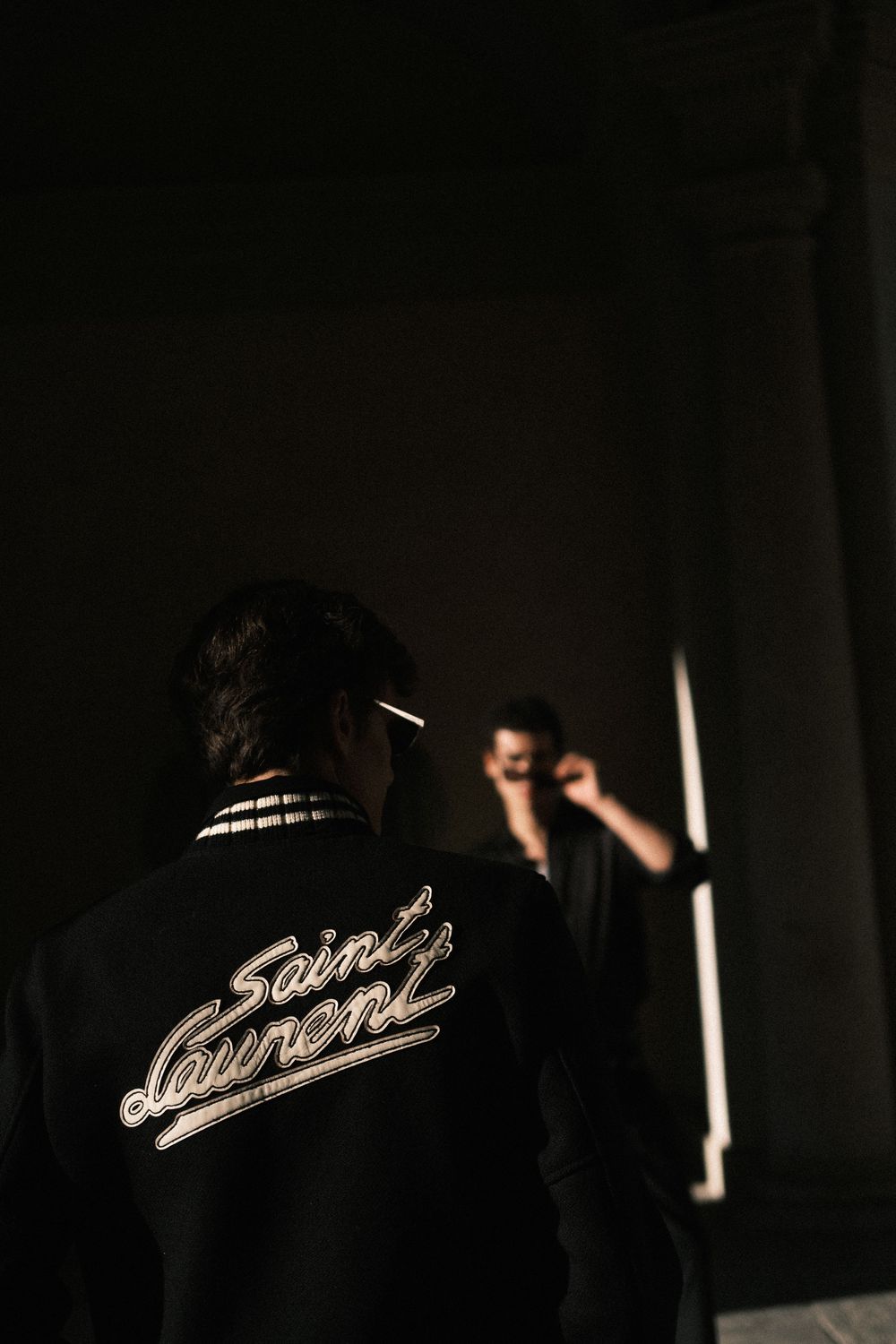 Dark jacket with illuminated text detail visible in low lighting conditions.