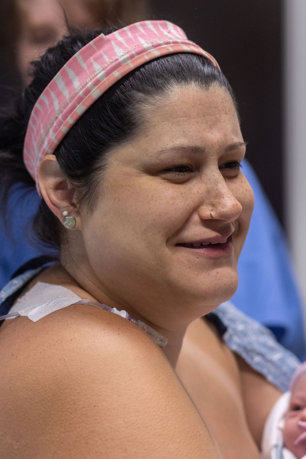 A woman wearing a pink headband shows emotional expressions while looking down.
