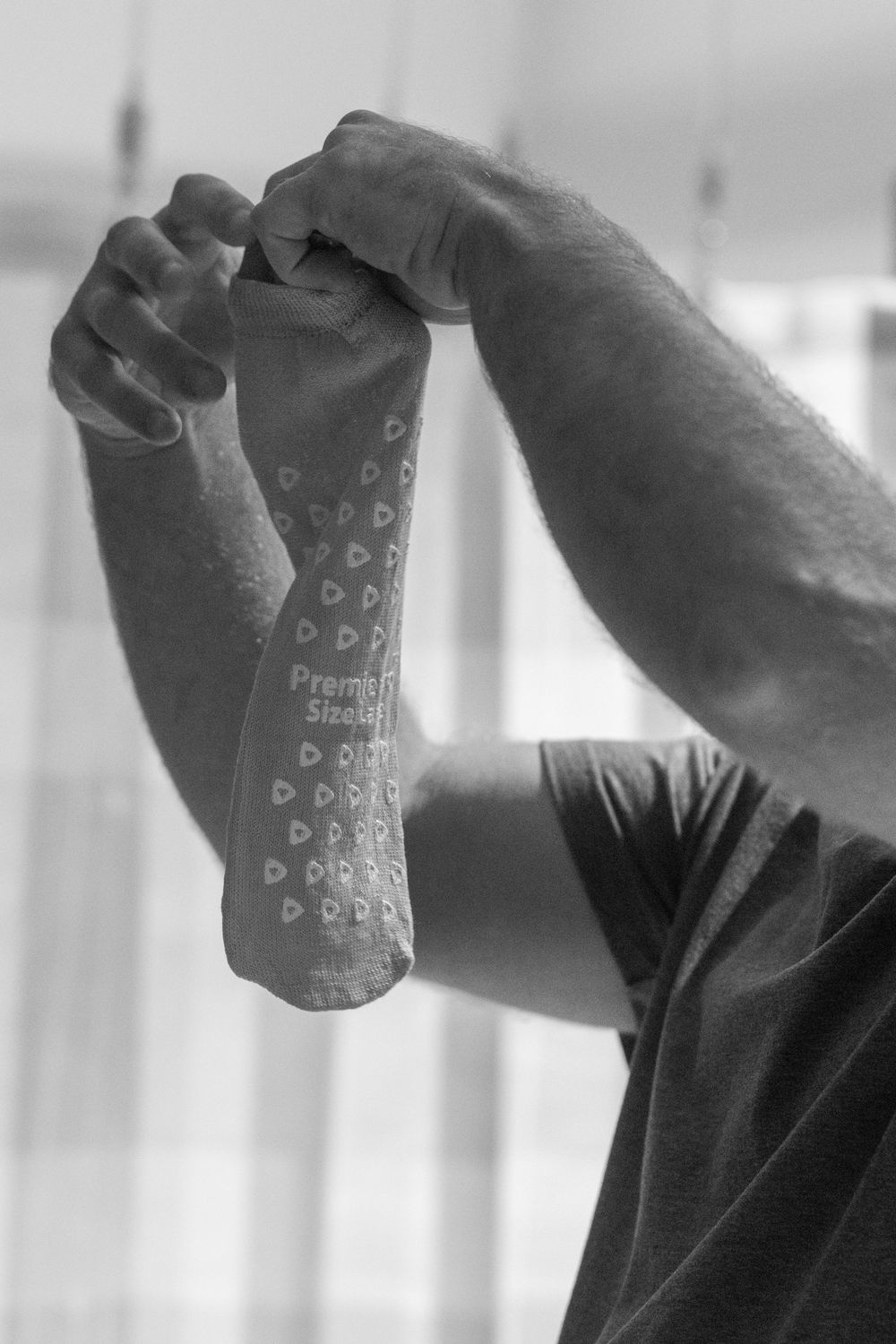 Black and white image of medical compression socks being put on.