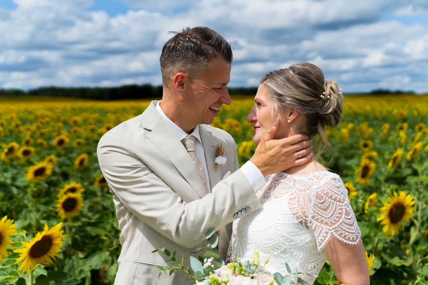 Hochzeitsfotograf Berlin, Brautpaar steht verliebt in einem Sonnenblumenfeld und schaut sich innig an