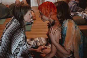 A small group sits closely together during an intimate wellness gathering.