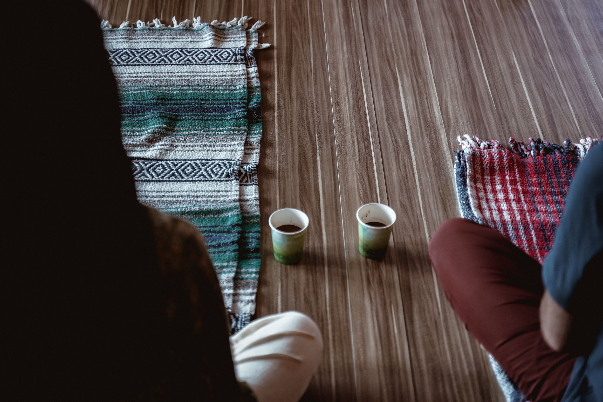 Tea cups on patterned rugs during a mindful gathering or ceremony.