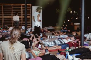 View of meditation or relaxation session with multiple participants on floor mats.