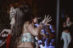 An energetic dance scene with blue lights and intricate wall decorations in the background.