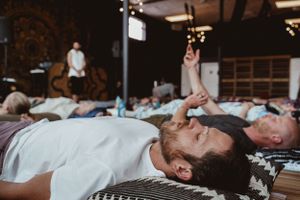 Participants lying on mats during group meditation or wellness class.