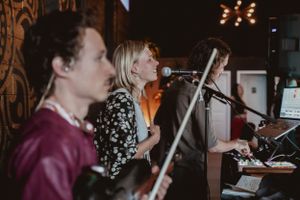 Musicians performing live with instruments and microphones on stage.