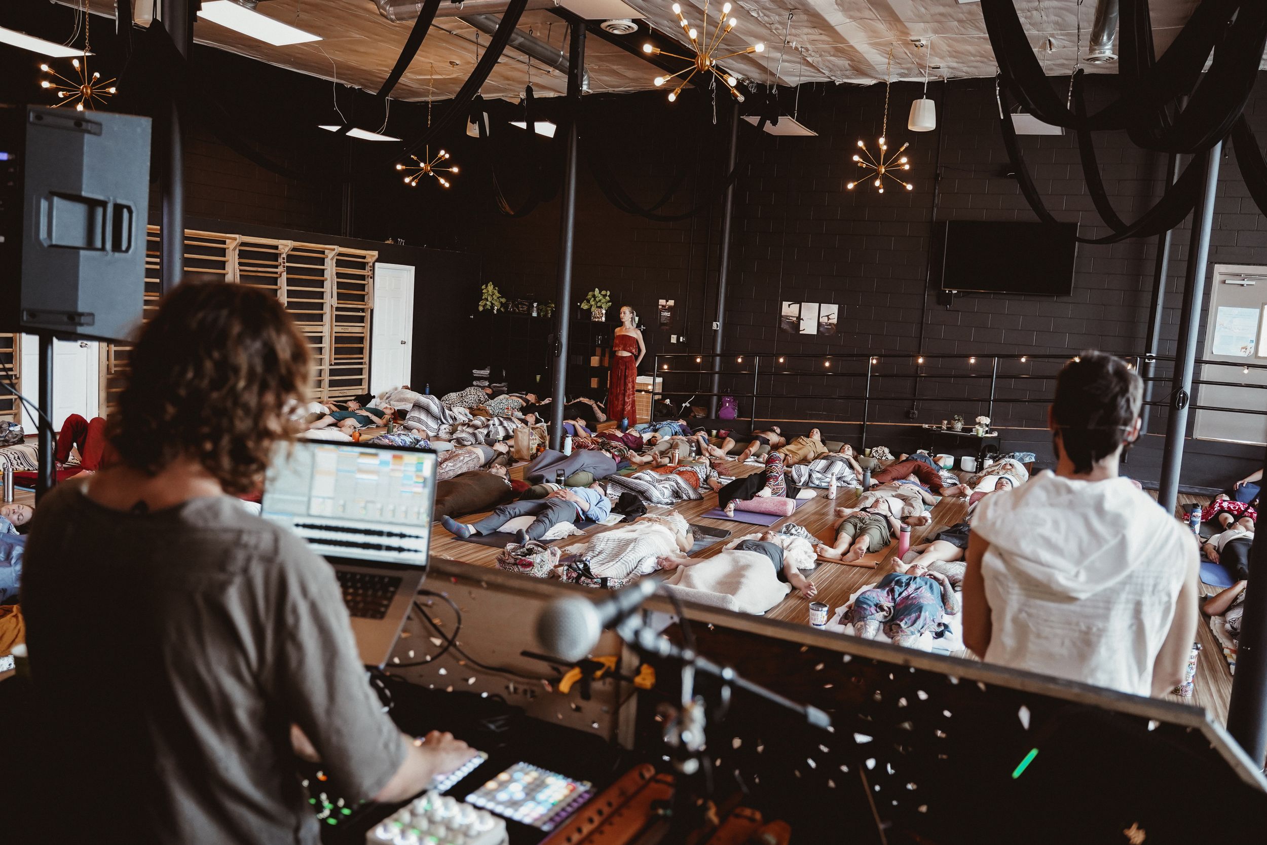 Musicians performing during a group meditation session in a studio space.
