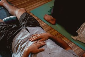 Hand resting on body during therapeutic massage or wellness treatment.