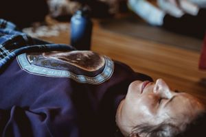 Person lying down during a meditation session with serene expression.