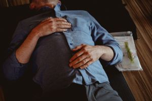 Hands placed on torso during therapeutic healing or relaxation session.
