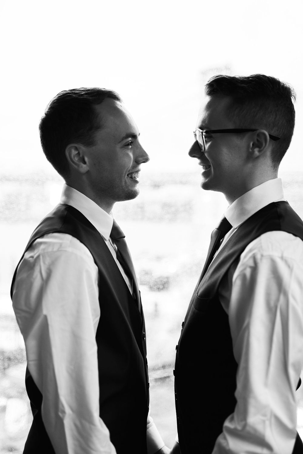 Artistic black and white lineup of people in formal attire showing profile views.