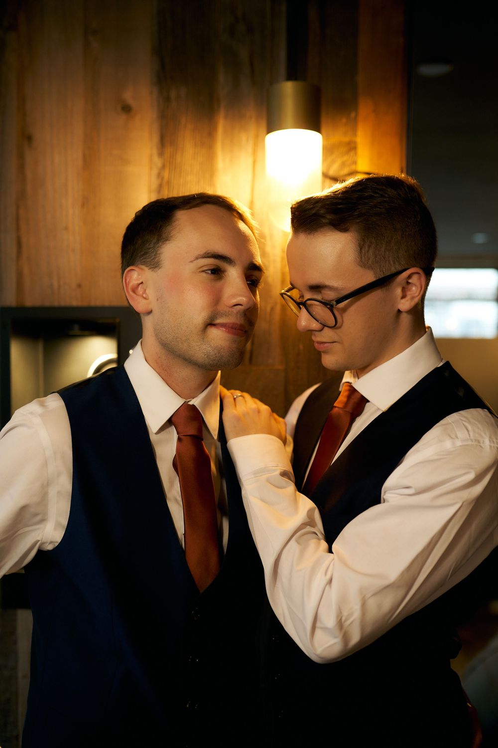 Intimate moment captured between couple in formal wear with warm lighting.