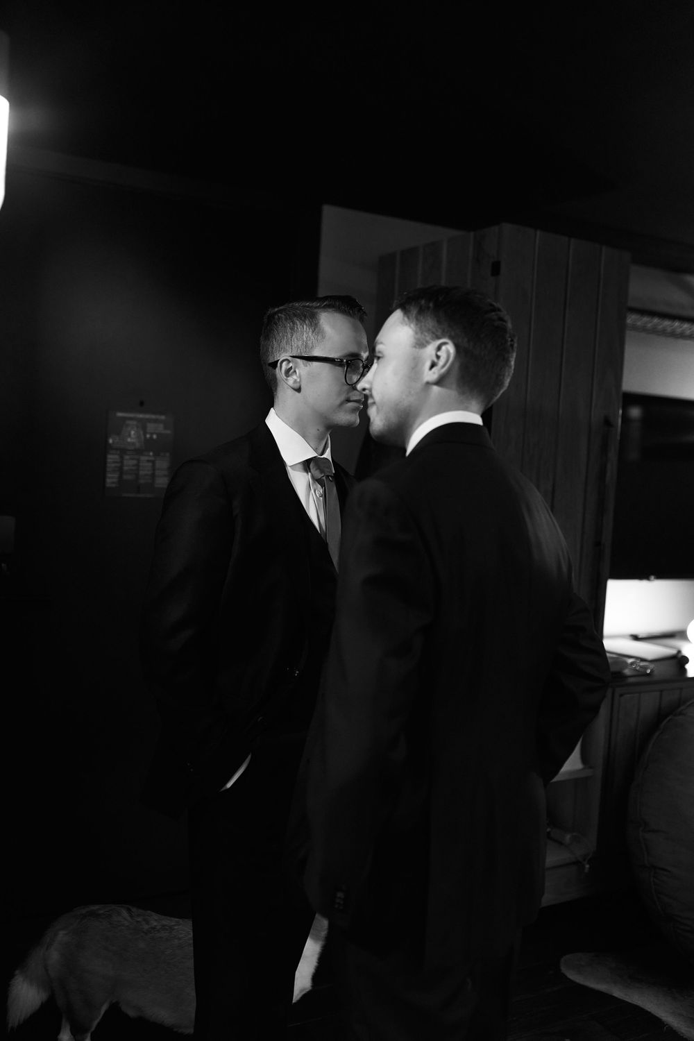 Dramatic low-light photo of couple in formal wear sharing intimate moment.