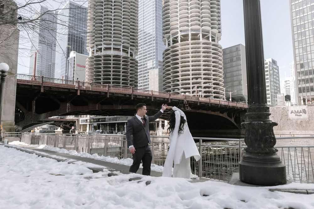 Snow covered riverwalk in downtown Chicago with Marina City towers and skyscrapers along the Chicago River.