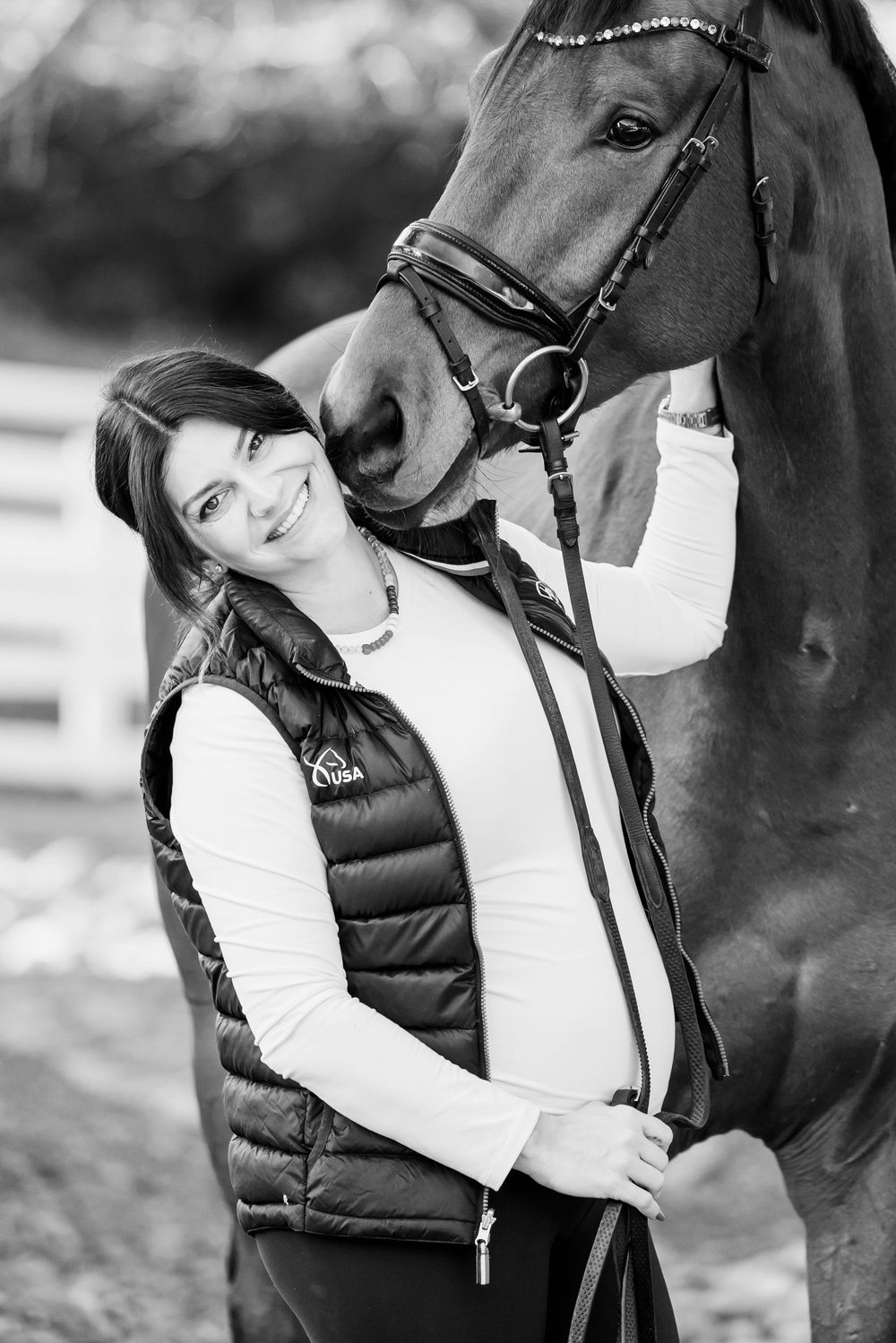 A person in a white jacket and black vest embraces a dark-colored horse in a series of intimate monochrome photos.