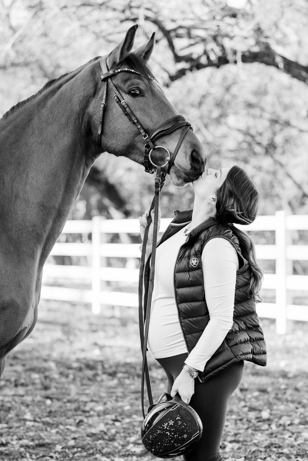 Black and white photo series showing close interactions between a horse and person against a white fence backdrop.