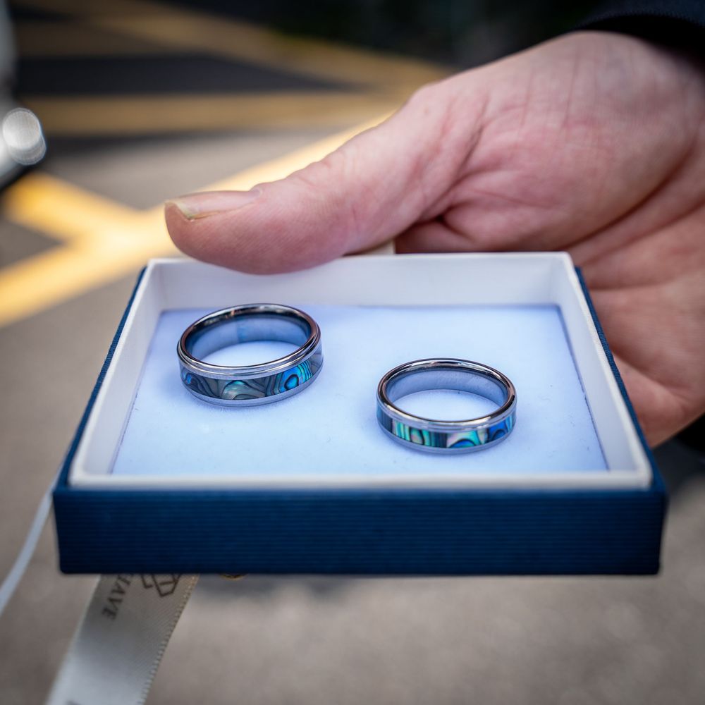 Close-up shots of matching silver and turquoise inlaid wedding bands displayed against a white background.