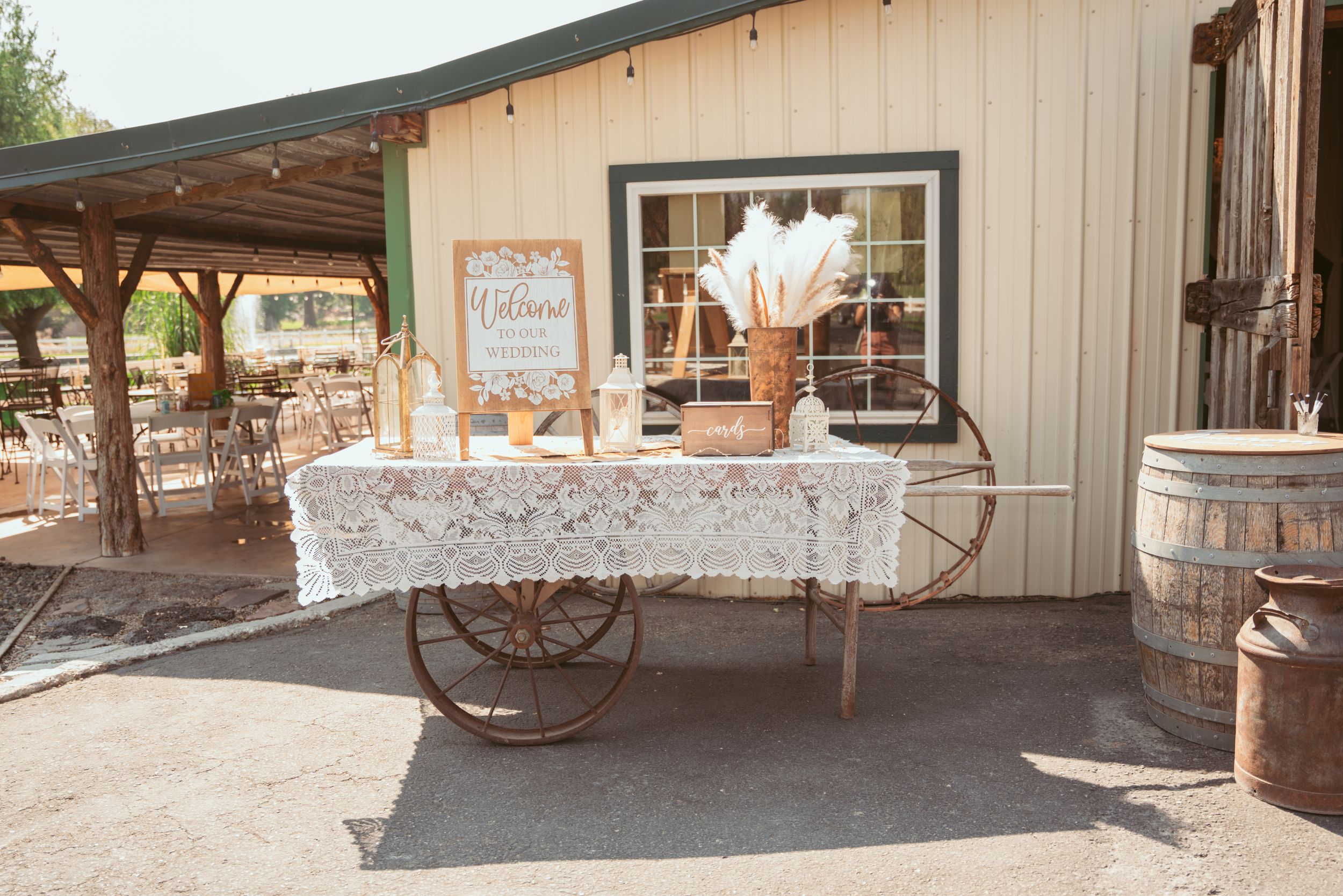 Wedding reception venue with rustic barn doors and white decor details creates an elegant outdoor setting.