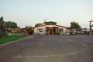 Panoramic view of a commercial parking lot with retail buildings and utility poles against a cloudy sky.