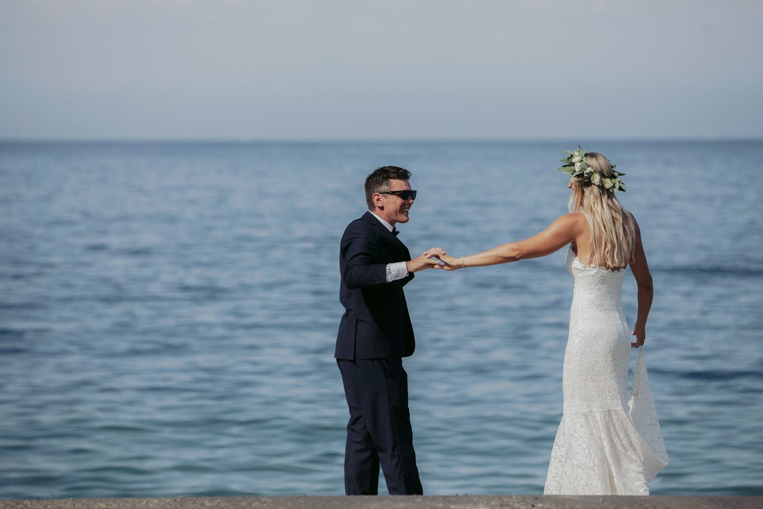 Couple at lakeside wedding venue share intimate dance and poses for photos at sunset.