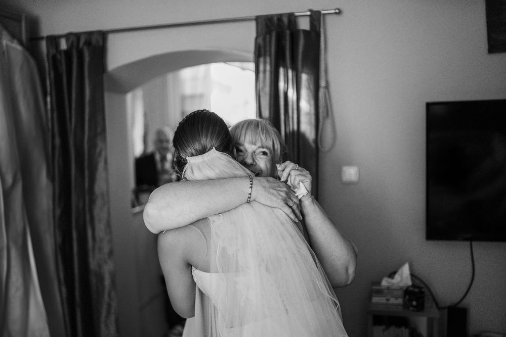 Black and white wedding photo collage showing intimate moments of dress preparation and details from the special day.
