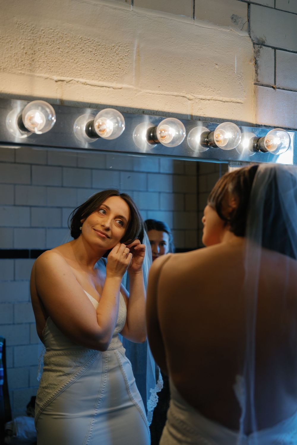 Bridal preparations in a dressing room with vanity lights.