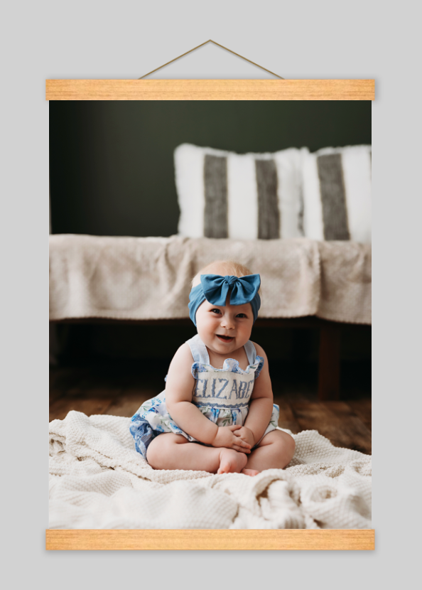 A sleeping newborn wrapped in soft white fabric is photographed in a series showing different angles of their peaceful pose.