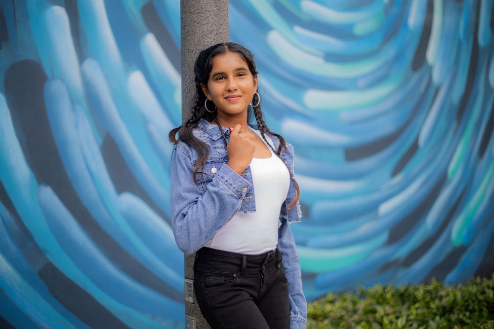 Girl posing for senior portraits in front of mural
