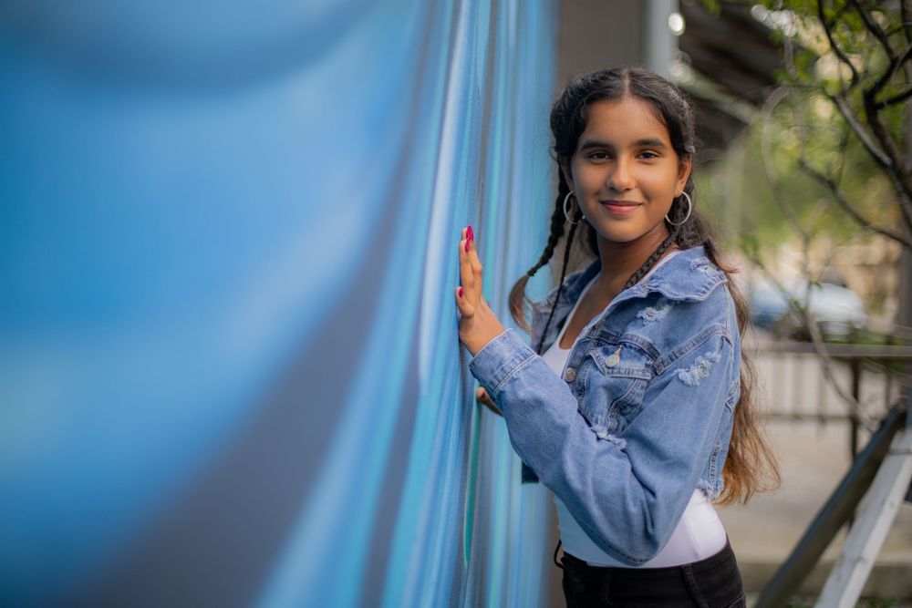 Girl posing for senior portraits in front of mural fun creative shot