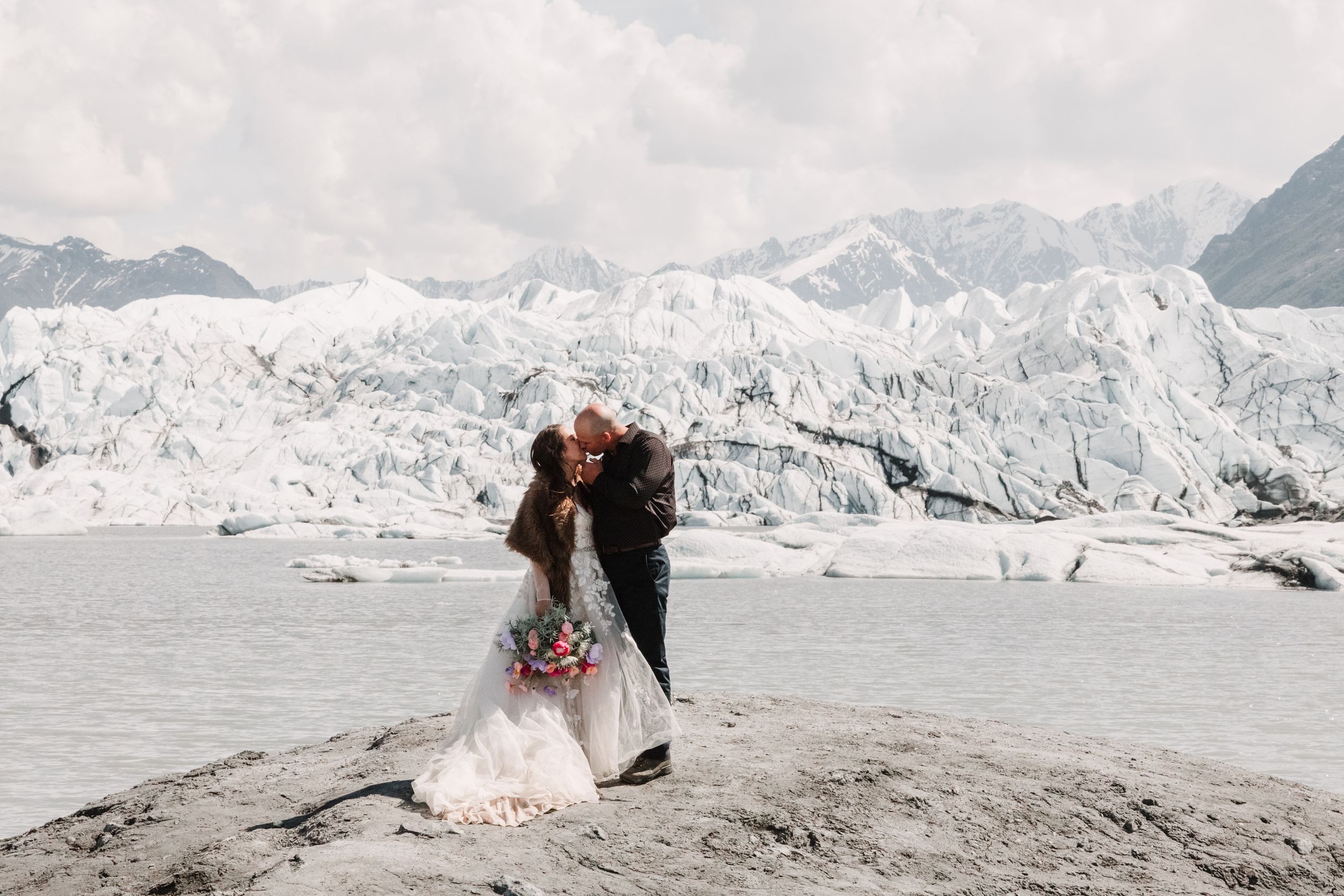 intimate elopement kiss on glacier overlooking stunning Wyoming views